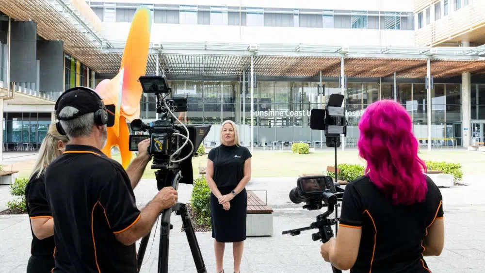 Xr:d:dafopbc7amc:3,j:2738584657287154102,t:23071012 Executive female ceo being interviewed on camera outside a hospital
