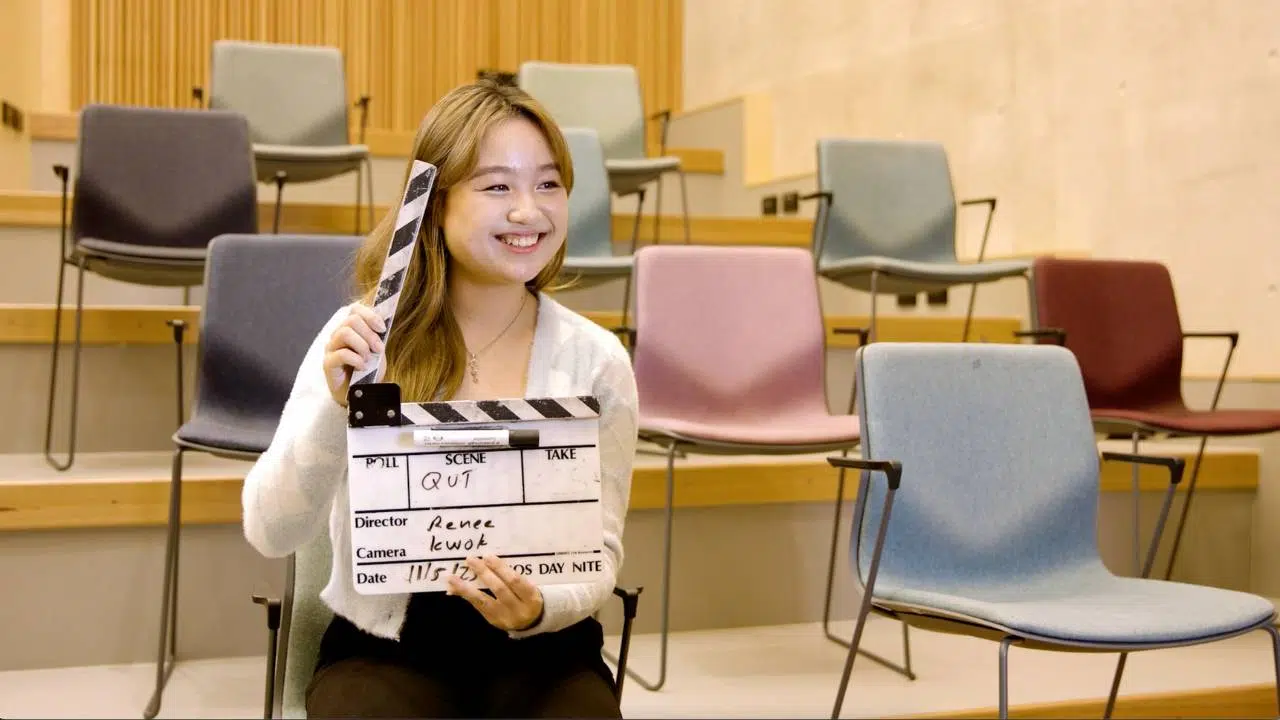 Reassure- your-interviewees Female interviewee in uni lecture room holding video clapper
