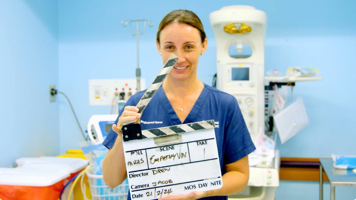 Female hospital employee with video clapper in front of her. Getting ready for training video filming