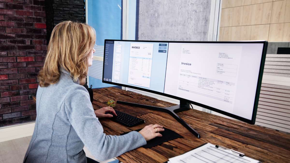 Add-video-to-invoice Woman looking at invoice with a video link on desktop screen